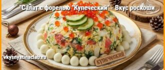 Салат с форелью Купеческий на белой тарелке, украшенный красной икрой и дольками свежего огурца, стоит на праздничном столе.
