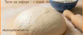 Тесто на кефире с содой для пирожков лежит на кухонном столе, присыпанном мукой.